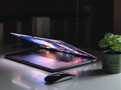 Colorful close up of a laptop keyboard working home or office at night with the illumination of a screen display with multiple colors background..